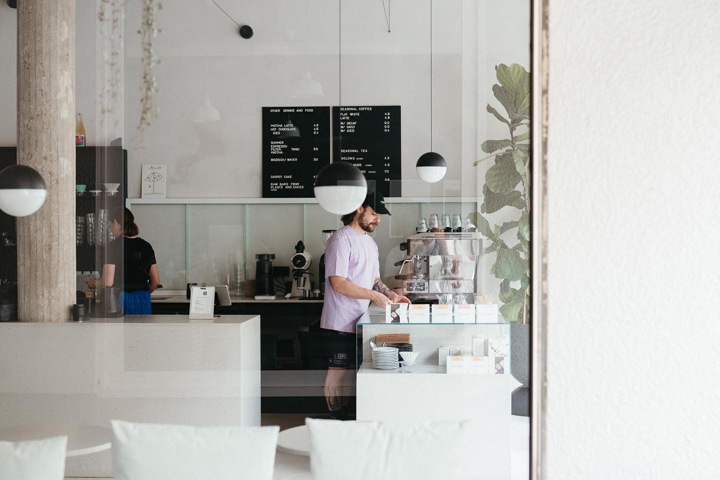 Ein Bild unseres ersten cafes, der drei Kaffeebar mit dem Barista stehend an der Kaffeemaschine.